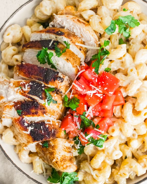 Instant Pot Cajun Chicken Alfredo topped with parsley and fresh diced tomatoes.