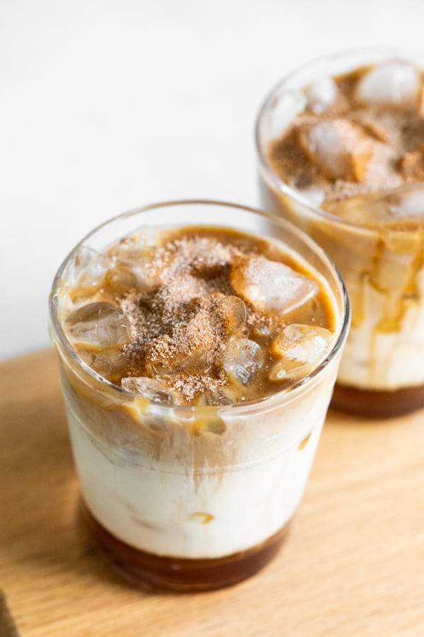 Apple Crisp Macchiato in a glass served with cinnamon sugar topping. 
