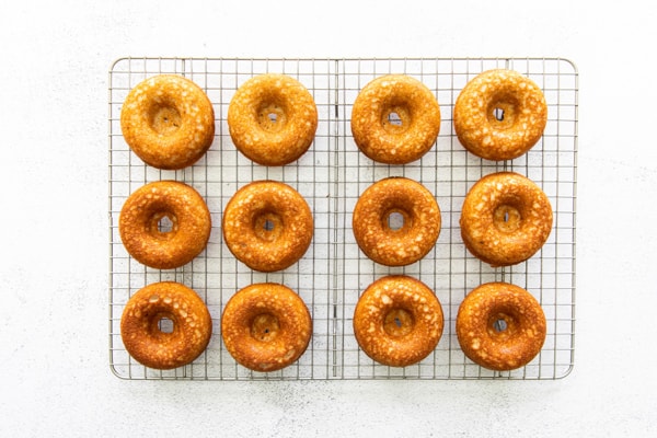 Baked apple cider donuts sitting on a cooling rack. 