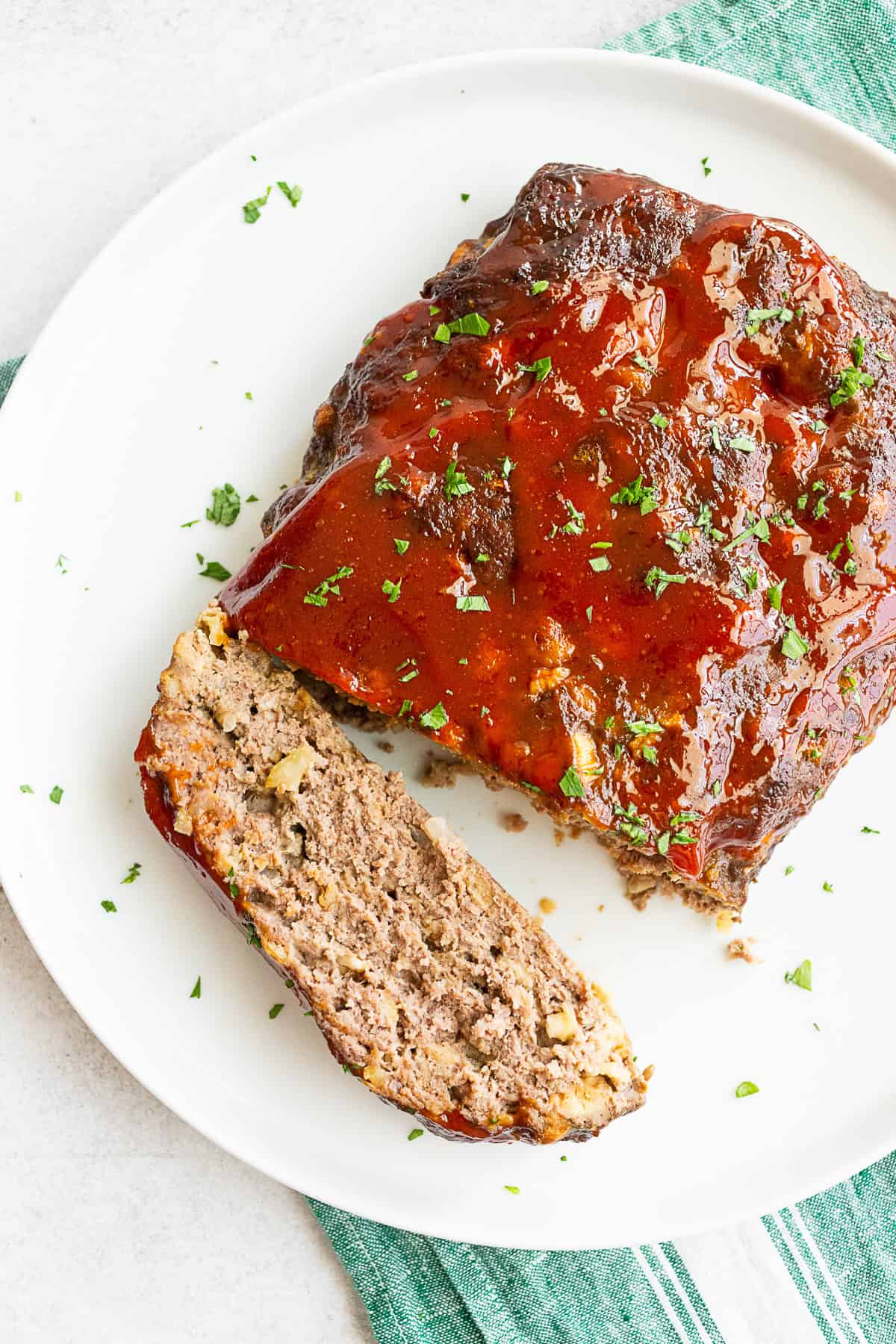 Classic Beef Meatloaf on a serving platter with a slice cut. 