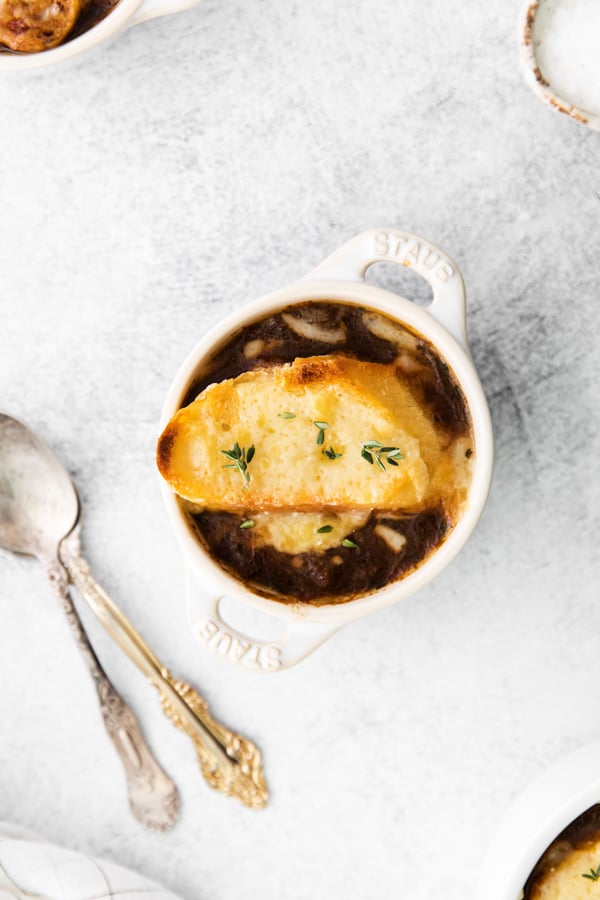 French Onion Soup in a small crock topped with cheesy toast. 