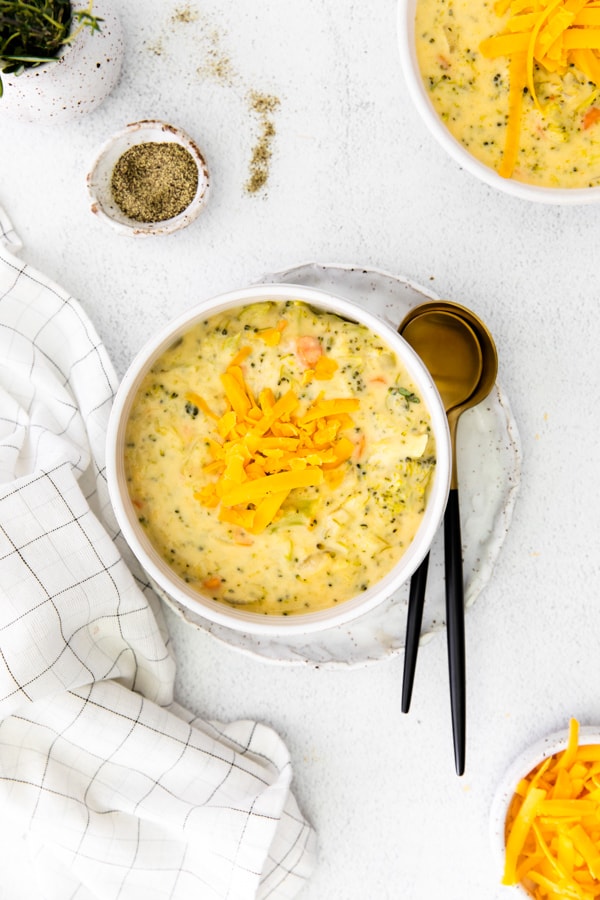 Instant Pot Broccoli Cheddar Soup in a white bowl with spoon. 
