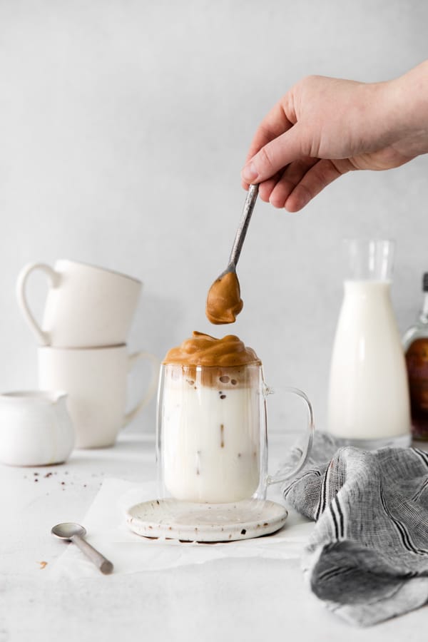 Topping Maple Whipped Coffee overtop iced milk. 