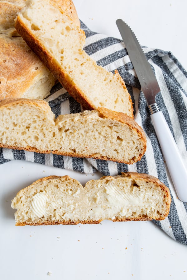 No Yeast Sourdough Bread sliced and spread with butter.