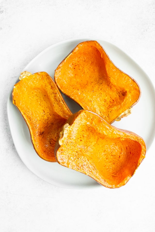 roasted honeynut squash sitting on a white plate.