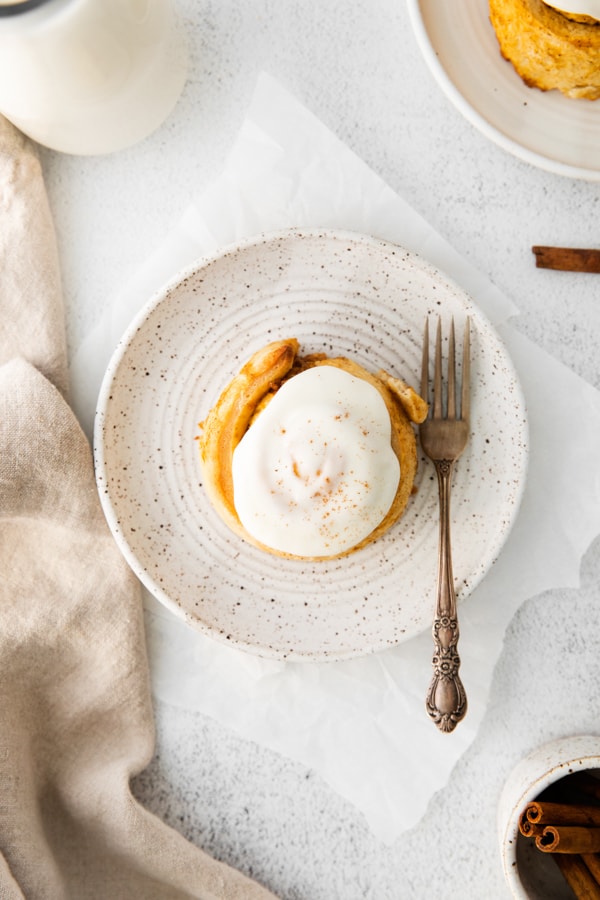Pumpkin Cinnamon Rolls on a plate served with a fork.