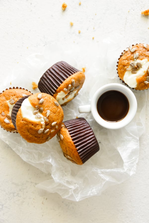 Pumpkin Cream Cheese Muffins sitting on a board with coffee.