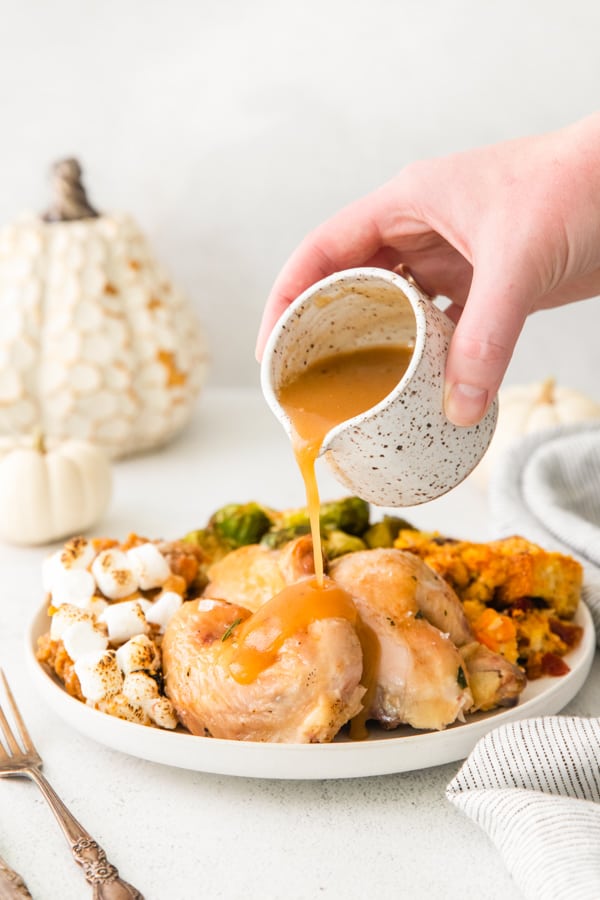 Pouring gravy over cut up Cornish hens.