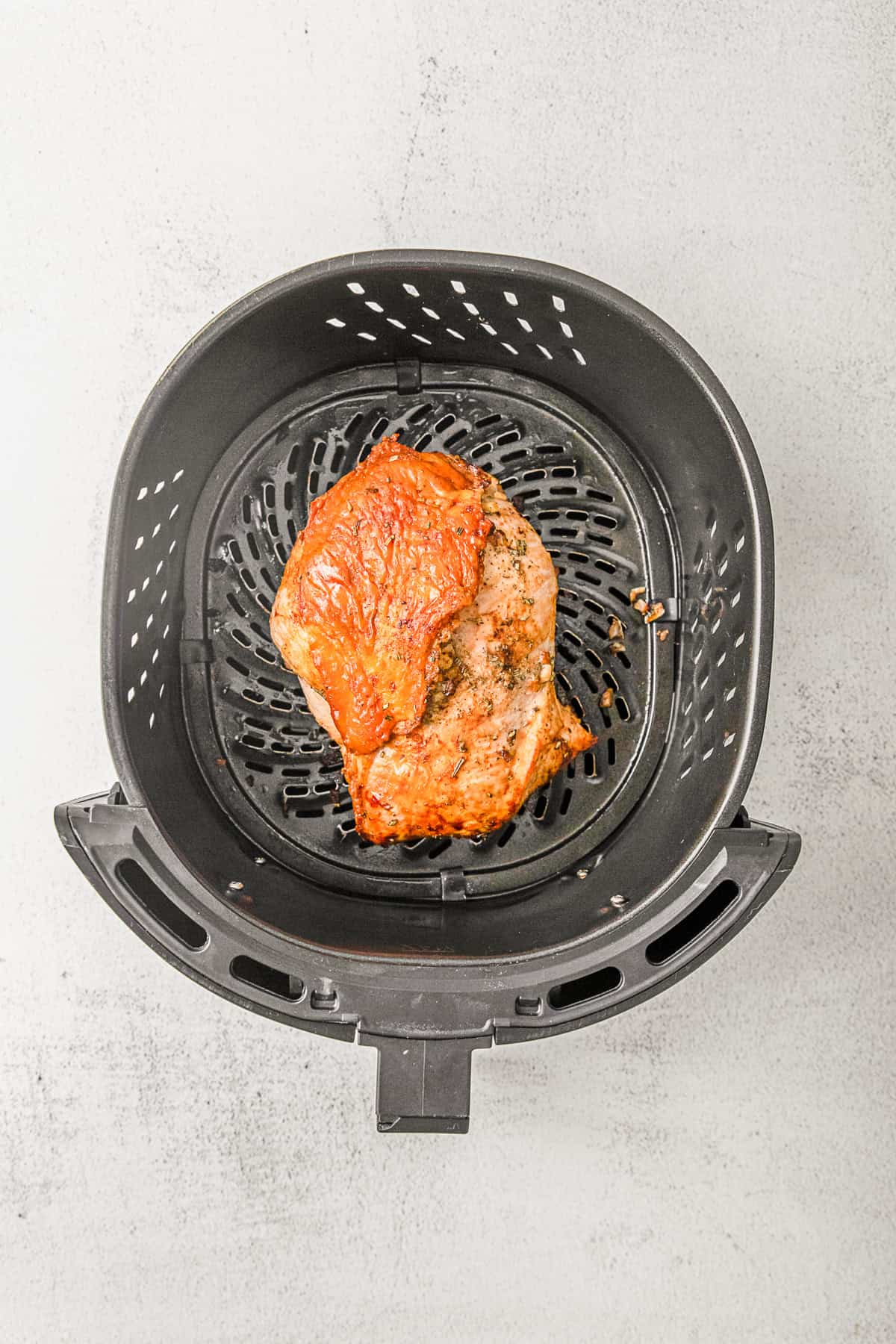 Air fried turkey breast in an air fryer basket.