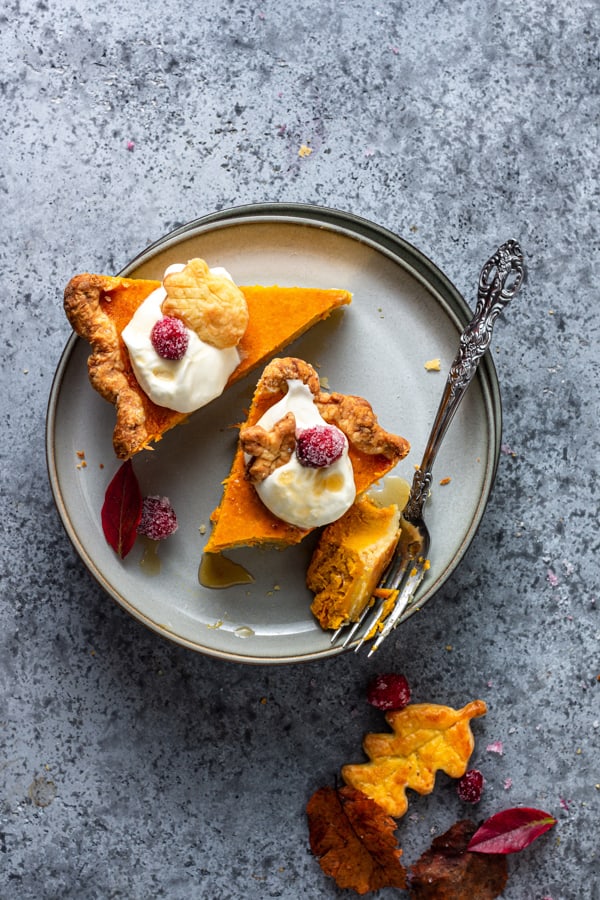 Pumpkin Cheesecake Pie sliced on a grey plate with a fork.