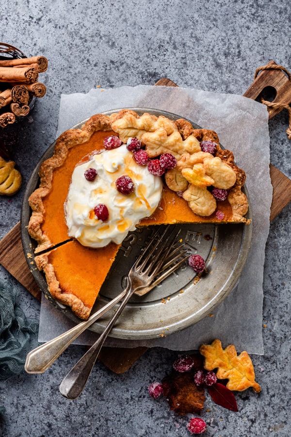 Pumpkin Cheesecake Pie cut with forks in the pie plate.