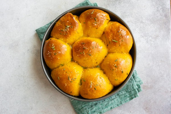 Rosemary Pumpkin Rolls in a round cake pan.