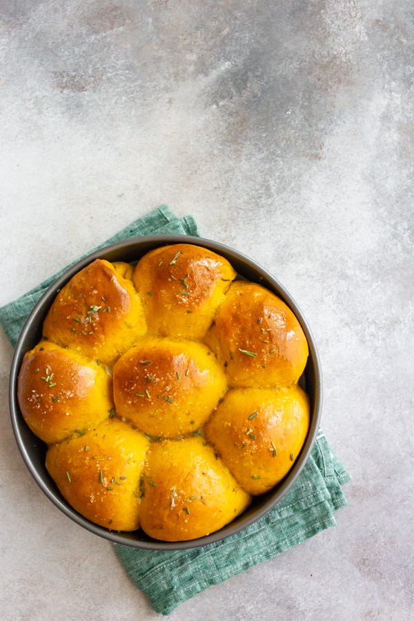 Rosemary Pumpkin Rolls in a round cake tin.
