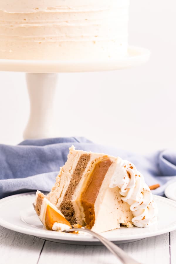 Thanksgiving Piecaken slice on a plate with a fork with the cake in the background. 