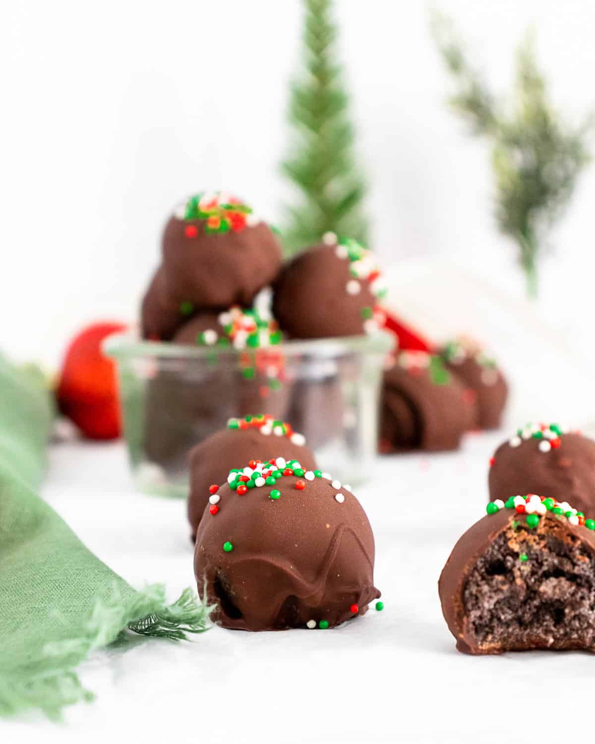 Christmas Oreo Truffles sitting on a white table.