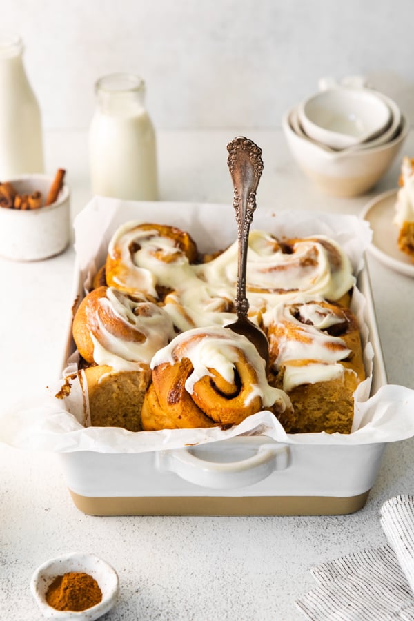 Cutting out a Gingerbread Cinnamon Rolls from a dish. 