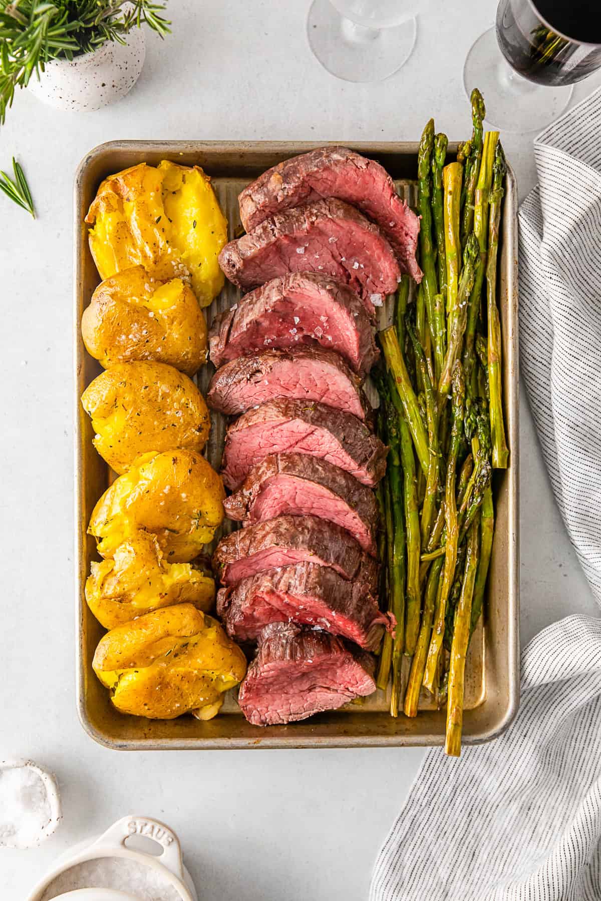 Sheet pan Christmas dinner served on the sheet pan with sliced beef tenderloin. 