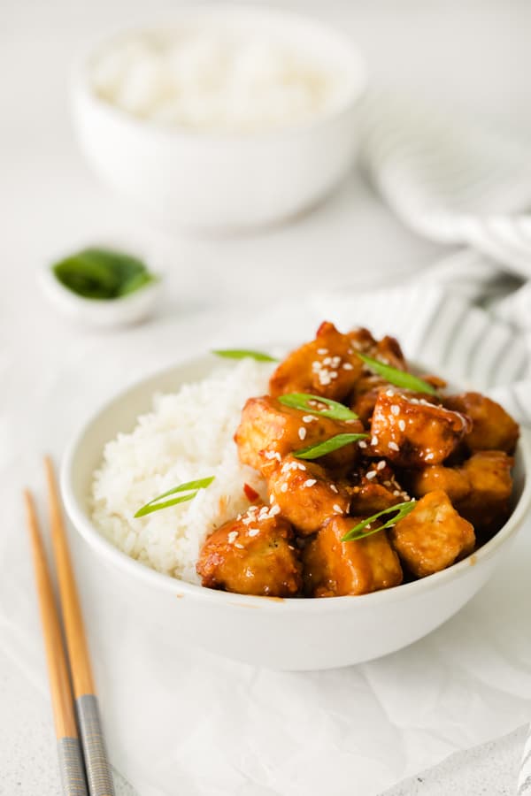 Air Fryer Sweet Chili Tofu in a bowl topped with green onions. 
