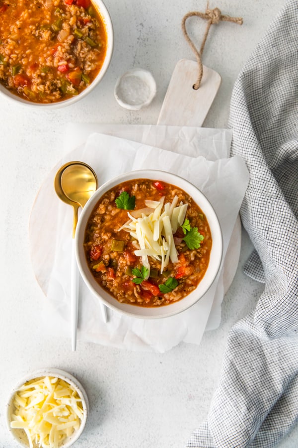 Instant Pot Stuffed Pepper Soup served with a spoon on a wooden charger.
