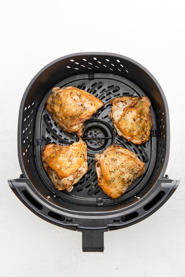 Air Fryer Chicken Thighs in a the air fryer basket. 