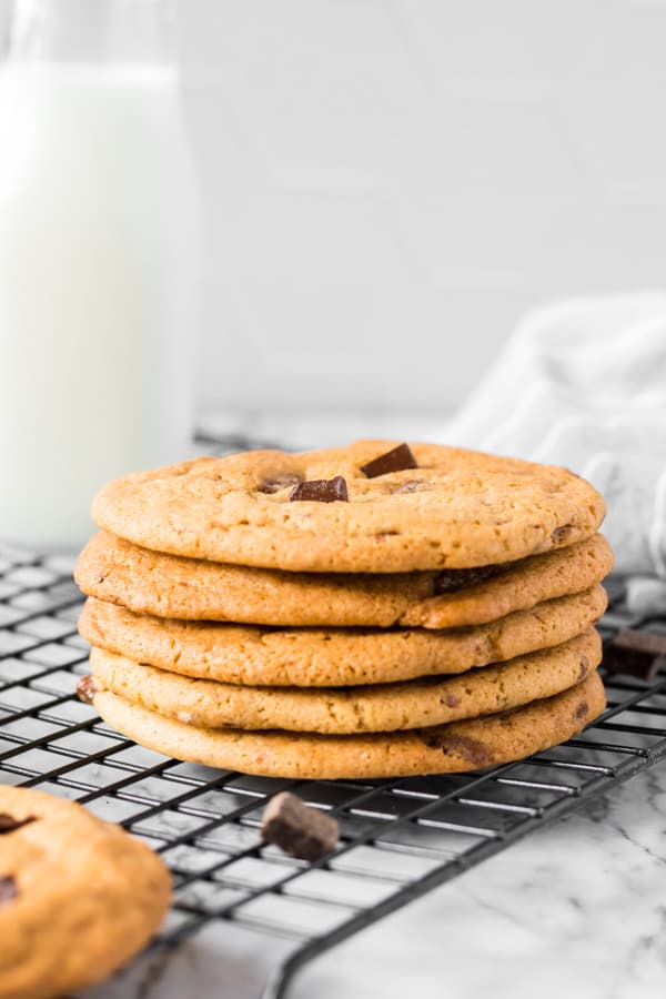 Caramel Chocolate Chip Cookies stacked on a cooling rack.