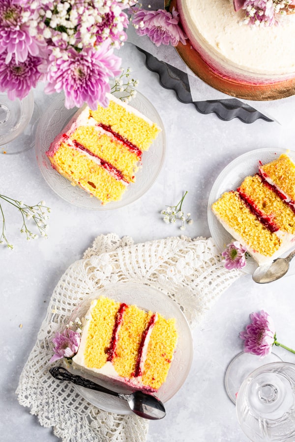 Slices of Strawberry Coconut Layer Cake on white plates. 