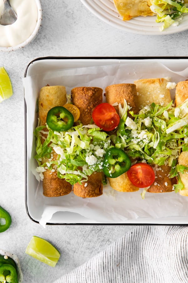 Air Fryer Chicken Taquitos served with toppings.