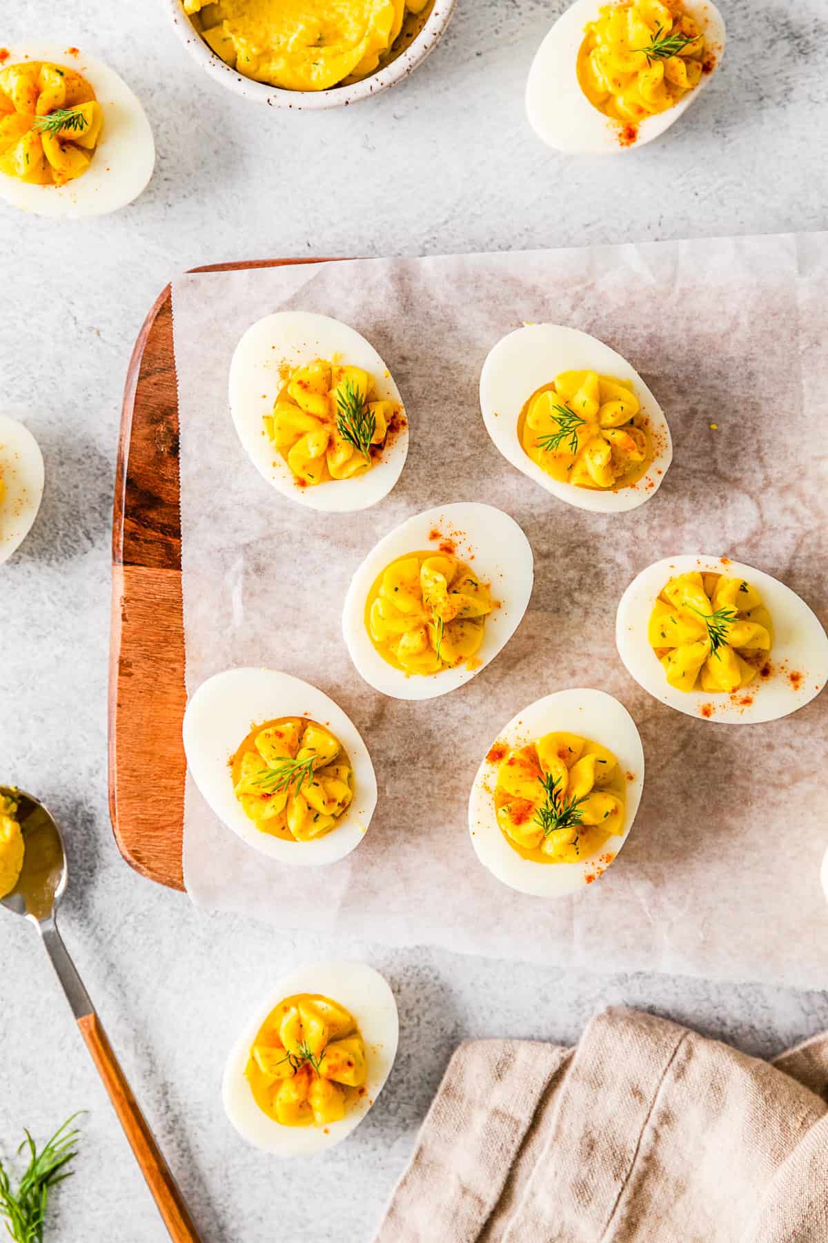 Classic Deviled Eggs served on a wooden cutting board. 
