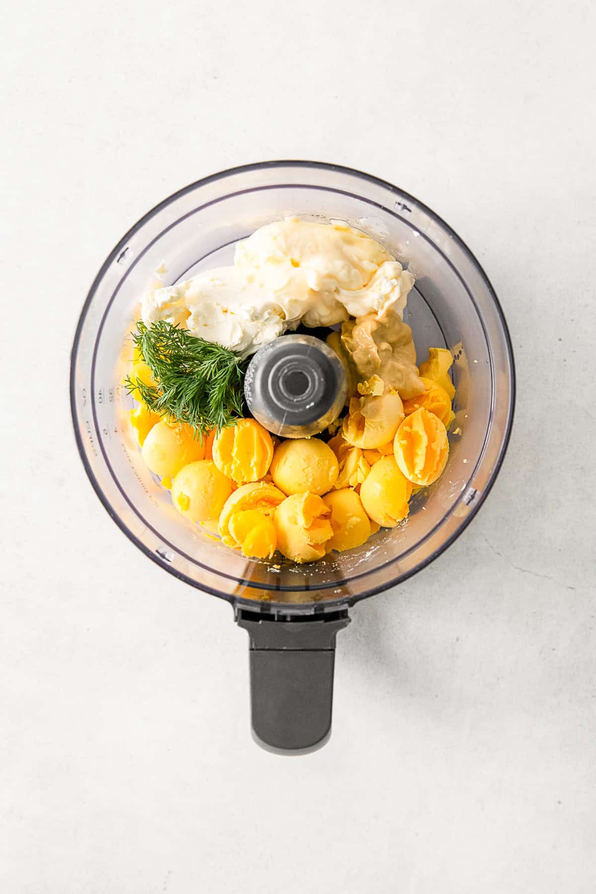 All the ingredients in a food processor for Classic Deviled Eggs. 