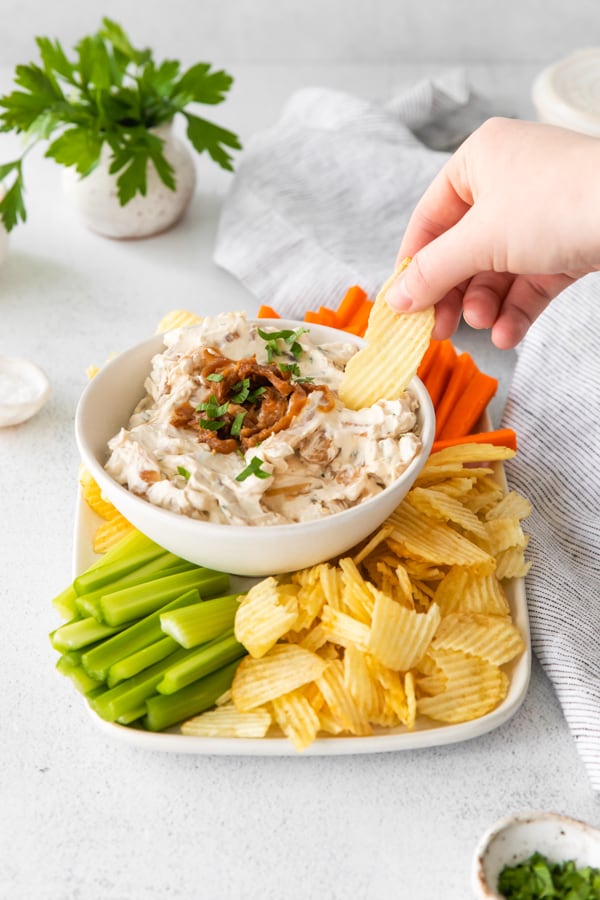 Using a chip to scoop up some French Onion Dip. 