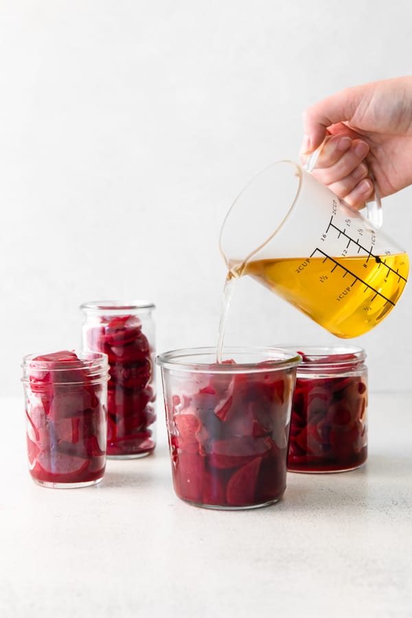 Pouring brine into jars of beets.