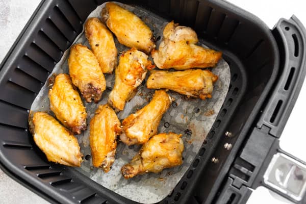 air fryer chicken wings in the basked of the air fryer.