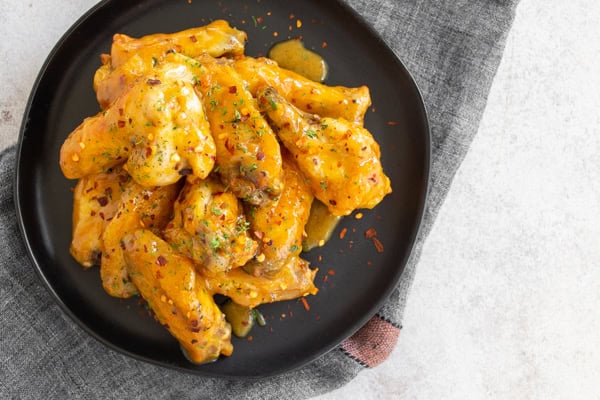 Air Fryer Honey Mustard Chicken Wings topped with crushed red pepper.