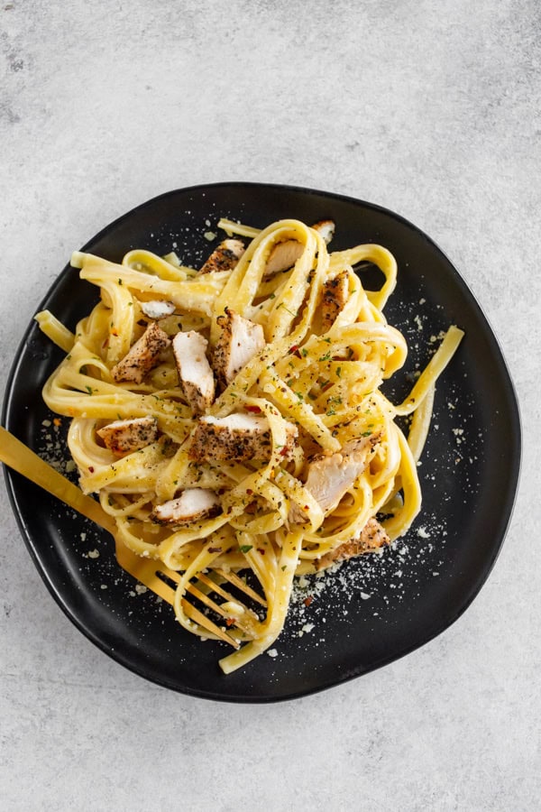 Chicken Fettuccine Alfredo served on a plate with a fork.