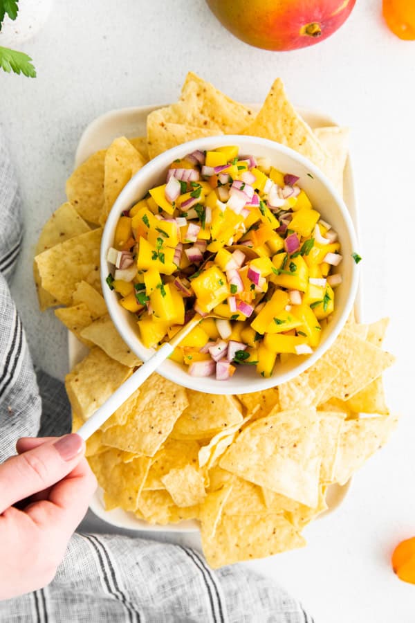 Mango Habanero Salsa served in a bowl with a spoon. 