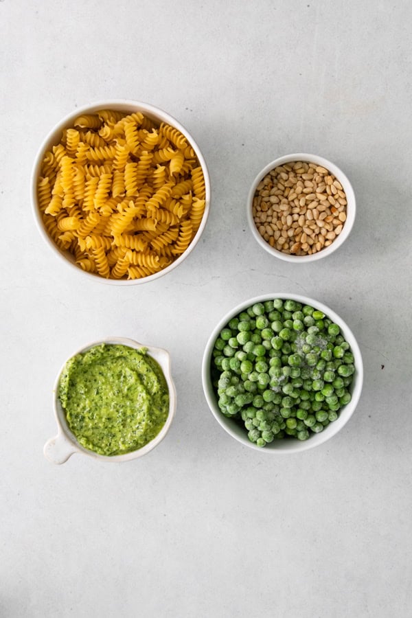 Pesto Pasta Salad ingredients on a table. 