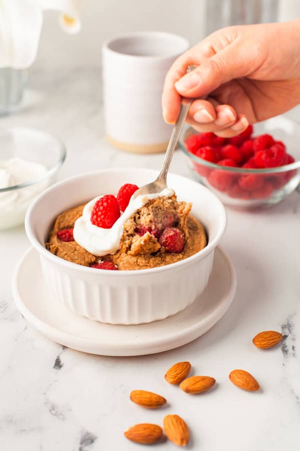 Someone spooning out a bite of Baked Raspberry Oatmeal.
