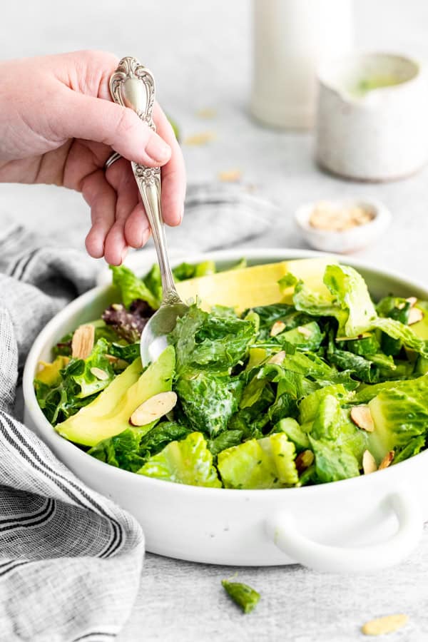 Picking up Green Goddess Salad out of a bowl. 
