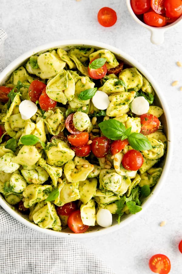 Pesto Tortellini Salad garnished with fresh basil.