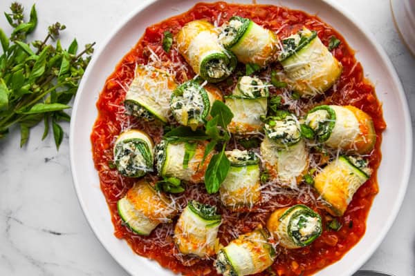 Zucchini Lasagna Rolls on a white round plate. 