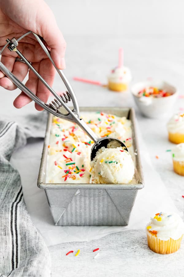 Birthday Cake Ice Cream being scooped out of its container.  