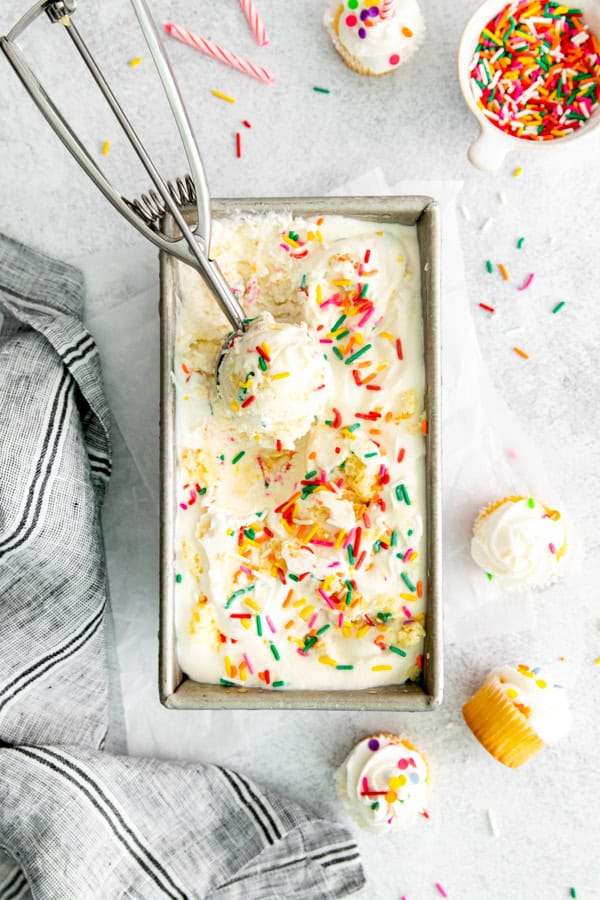 Birthday Cake Ice Cream in a metal pan with an ice cream scooper. 