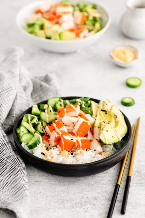 California Roll Sushi Bowl served with spicy mayo and chopsticks.