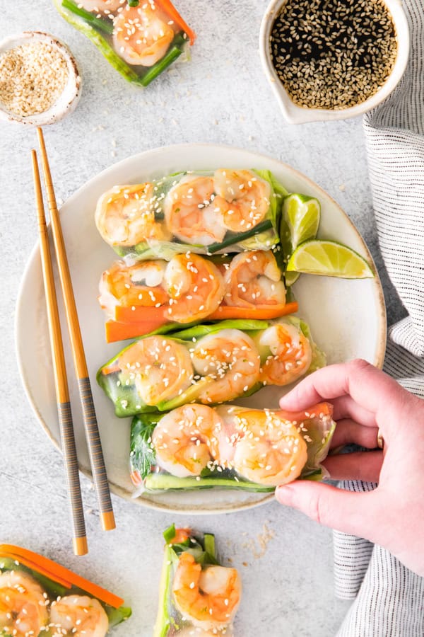 A hand picking up a Shrimp Summer Rolls. 