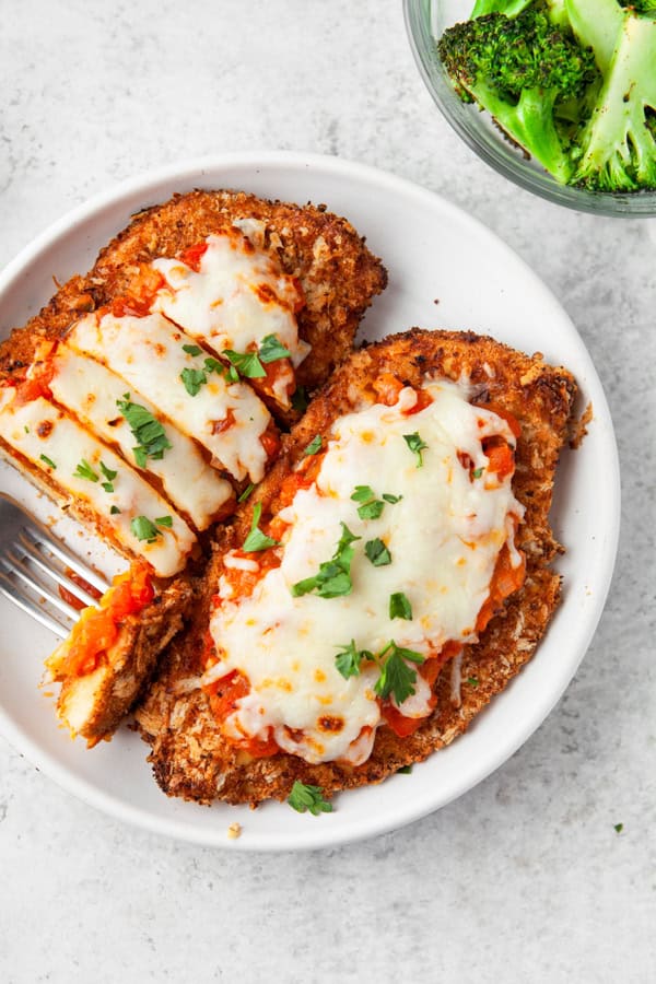 Air Fryer Chicken Parmesan on a plate cut into bite size pieces.