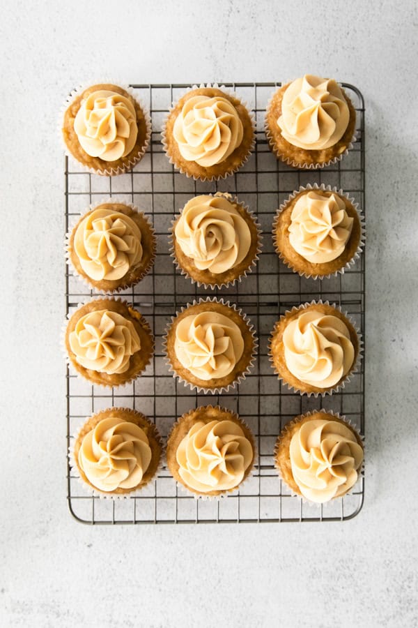 Frosted cupcakes on a cooling rack.