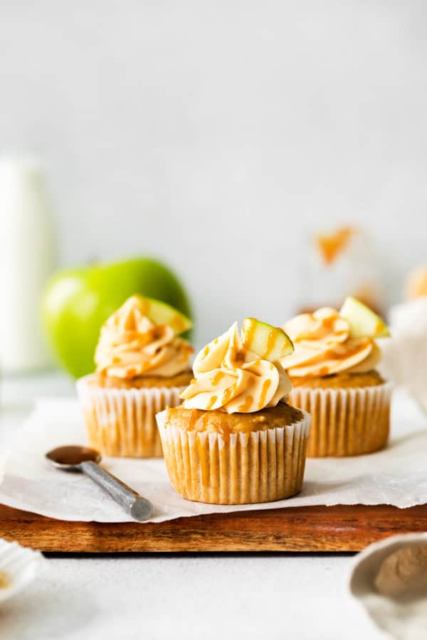 Apple cupcakes topped with frosting and caramel sauce.
