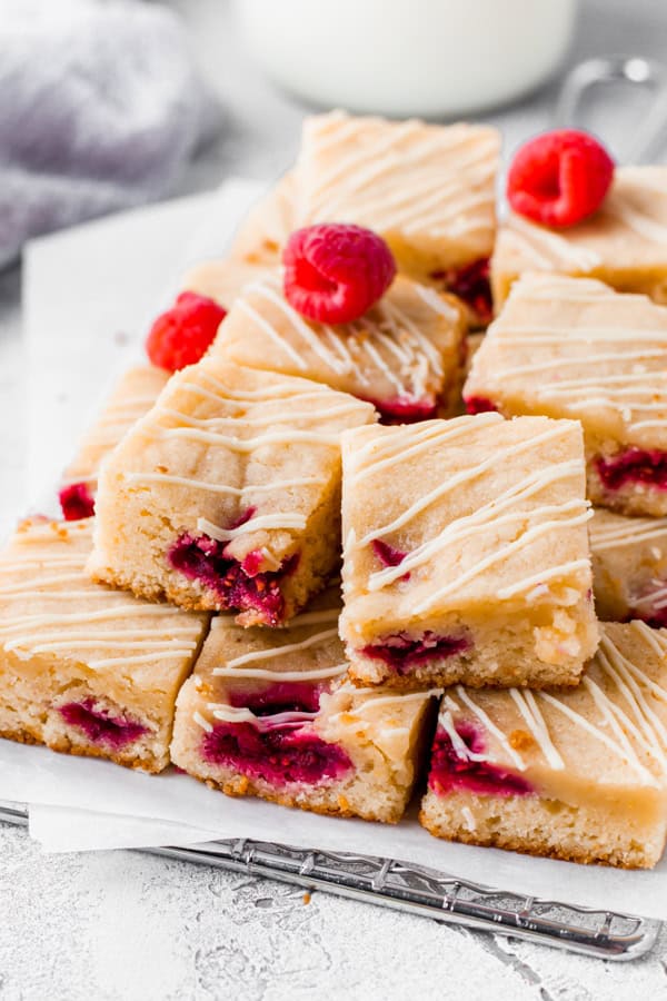 Cut White chocolate raspberry blondies on parchment paper.