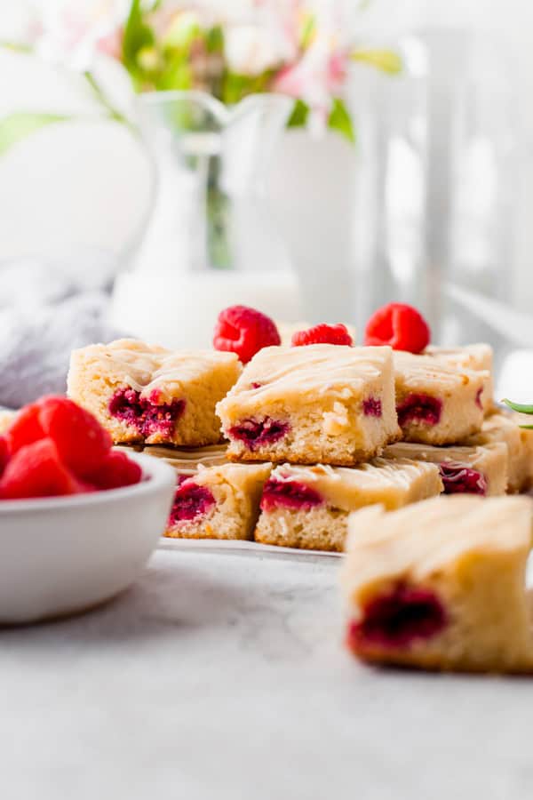 White chocolate raspberry blondies sitting on a table stacked.