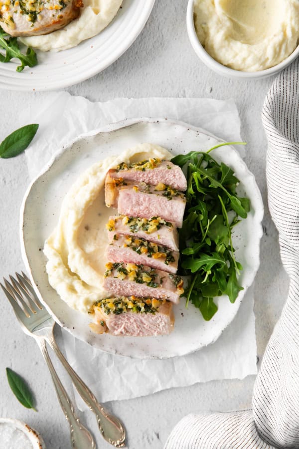 Air Fryer Pork Chops served on a plate with mashed potatoes and salad. 